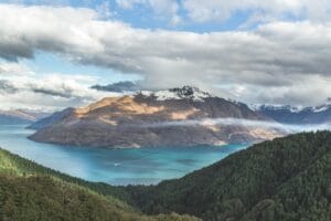Fotografia de paisagem de montanhas sob céu nublado entre corpos de água durante o dia