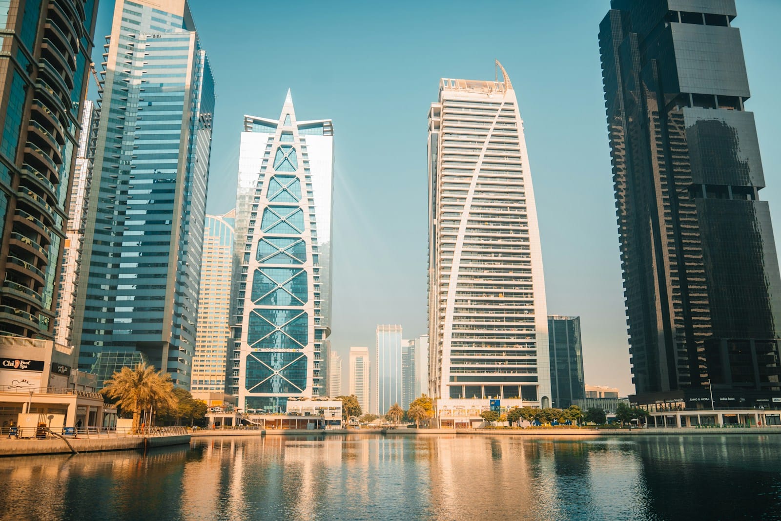 Arranha-céus modernos refletem-se na água de uma cidade.